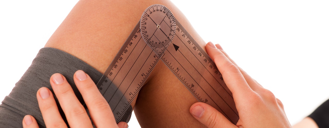 physiotherapy -therapist excercising with patient using gonometer to check the joint mobility of knee